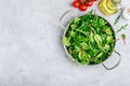 Mix of fresh leaves with arugula, lettuce, spinach, beets. Ingredients for salad on a gray stone background