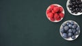 Mix of fruits on white bowls on dark background with copy space. Concept of juicy, fresh, organic and healthy. Top view of