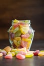 Mix of fruity jelly candy in jar on black table