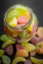 Mix of fruity jelly candy in jar on black table