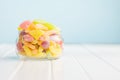 Mix of fruity jelly candy in jar on white table