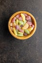 Mix of fruity jelly candy in wooden bowl. Top view