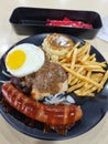 Mix grilled of jumbo sausage, egg, fries, chicken chop and mashed potato Royalty Free Stock Photo