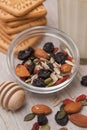 Mix of Healthy Nuts and Dried Fruits on Rustic Wooden Background. Glass of Milk and Biscuits. Wooden Honney Spoon. Top view.