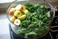 mix of kale, spinach, and apple going into a blender for a green smoothie