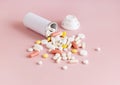 Mix of medical capsules and pills with a bottle on light pink top view. Medicinal treatment Royalty Free Stock Photo