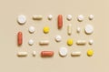 Mix of medical capsules and pills in a lines on light beige top view. Dietary supplements Royalty Free Stock Photo