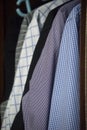 Mix of men`s shirts hanged in wardrobe