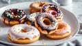 Mix of multicolored sweet donuts on white plate