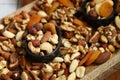 Mix of nuts and dried fruits on a wooden board and in a bowl. Healthy sweets Royalty Free Stock Photo