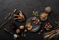 Mix of nuts and spices for baking cakes in bowl and spoon, cinnamon, star anise, hazelnuts, walnuts, wheat, lavender on dark table