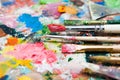 Mix of paints and paintbrushes close up Royalty Free Stock Photo