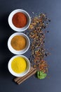 Spices and herbs bowls on a dark background