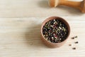 Mix peppercorns black, white, red and allspice in a wooden pestle with a chime for a mortar on a wooden background. Royalty Free Stock Photo