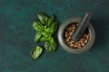 Mix of peppercorns, in a mortar for spices, oregano leaves, concept, on a dark green background, top view,