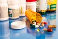 Mix of pills capsules supplements and Pharmacogenomics on blue medical table
