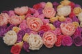 Mix of pink and Peach Fake Plastic Mini rosess Flowers Black Background copy space. Craft, Art, Hobby concept. Royalty Free Stock Photo