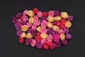 Mix of pink and Peach Fake Plastic Mini rosess Flowers Black Background copy space. Craft, Art, Hobby concept. Royalty Free Stock Photo