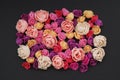 Mix of pink and Peach Fake Plastic Mini rosess Flowers Black Background copy space. Craft, Art, Hobby concept. Royalty Free Stock Photo