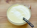 Mix pounded chicken egg yolks with sugar and beaten egg whites in a glass bowl on a wooden background. Royalty Free Stock Photo