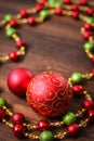 Mix of red, green, and golden Christmas balls. New Year decor for tree on dark wooden background