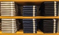 Mix Size of Pile Classic Light Gray, Blue and Black Jeans Texture with Paper Tag Exhibit on Wooden Shelf