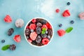 Mix of summer frozen berries in a white bowl on a blue concrete background. Copy space Royalty Free Stock Photo