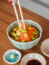 Mix sushi donburi in a small bowl , Japanese food. Focus on food at the chopsticks