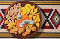 Mix of Turkish sweets, nuts and dried fruits - pears, figs, pineapples on a wooden platter. Flat lay view of oriental sweets,