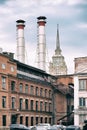 Mix of two pipes and buildings of different times against blue sky. Old Industrial building of the factory from red Royalty Free Stock Photo