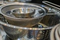 A colander, strainer and small plates in a drawer.