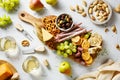 Mixed antipasti cheese, meat sticks, olives and crackers served on wooden board.