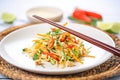 mixed asian slaw on white plate, chopsticks on side