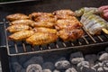 Mixed assortment of marinated meat, chicken, and prawns grilling on hot coals on a BBQ Royalty Free Stock Photo