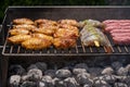Mixed assortment of marinated meat, chicken, and prawns grilling on hot coals on a BBQ Royalty Free Stock Photo