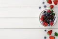 Mixed berries in glass bowls on white wooden table top view Royalty Free Stock Photo