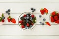 Mixed berries in glass bowls on white wooden table top view Royalty Free Stock Photo