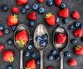 Mixed berries laying in three spoons with berries around the spoons Royalty Free Stock Photo