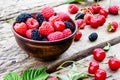 Mixed berries of raspberry, cherry, mulberry in a bowl on wooden background Royalty Free Stock Photo