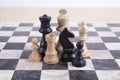 Mixed black and white wooden chesspieces on chessboard Royalty Free Stock Photo