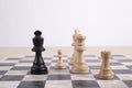 Mixed black and white wooden chesspieces on chessboard