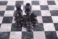Mixed black wooden chesspieces on chessboard Royalty Free Stock Photo