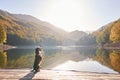 Mixed Breed Dog Elegantly Dancing on a Wooden Pier by a Tranquil Mountain Lake Autumn Foliage