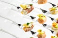 Mixed canapes on metal forks. White background