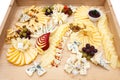 Mixed cheeses on a large light wooden board