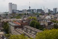 Mixed classic architecture of Rotterdam leafy urban apartment buildings in foreground with modern city high rise, tall towers and