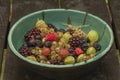 Mixed color garden fruit on wooden brown table and orange and green dish Royalty Free Stock Photo