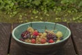 Mixed color garden fruit on wooden brown table and orange and green dish Royalty Free Stock Photo