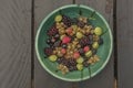 Mixed color garden fruit on wooden brown table and orange and green dish Royalty Free Stock Photo