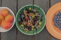 Mixed color garden fruit on wooden brown table and orange and green dish Royalty Free Stock Photo